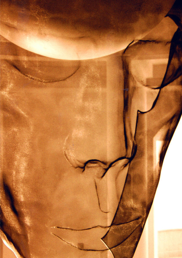 large wire-mesh sculpture of a face in copper colour