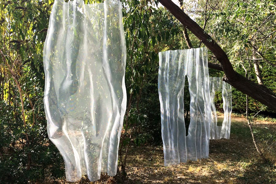 White-painted bronzemesh sculpture in a summer garden