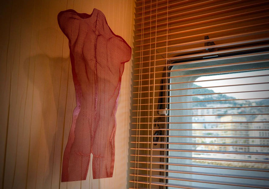 VENIS III - red coloured steel sculpture of a muscular body