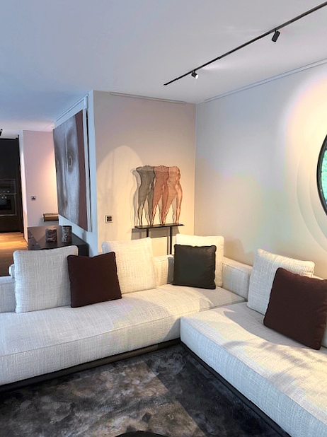 A modern living room ambience including lounge seating and a transparent feminine sculpture by artist David Begbie