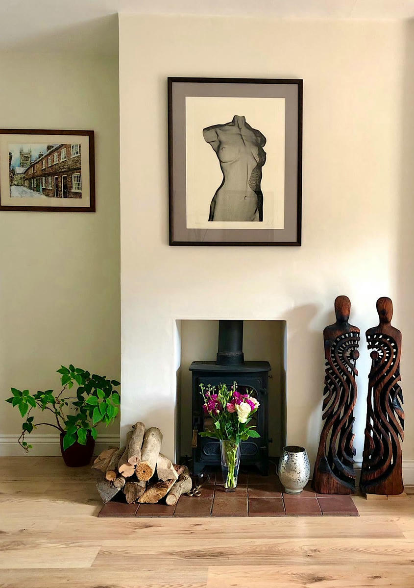 Fireplace with an art collection of a sculpture and an etching