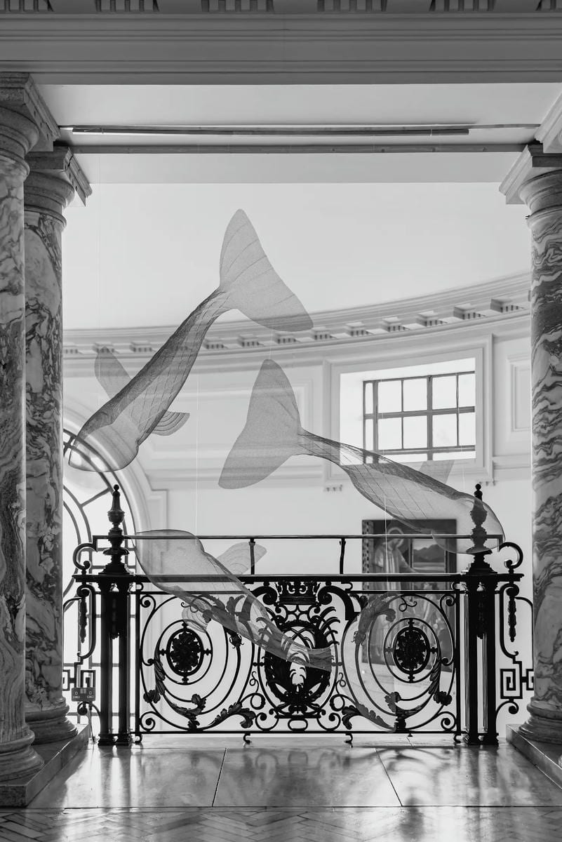 Staircase at Central Hall Westminster, London with suspended sculptures of three fish artworks by sculptor David Begbie