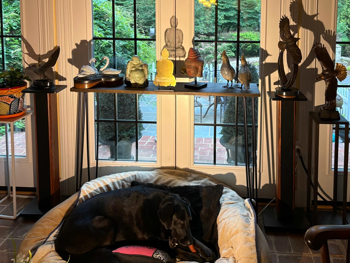 A living room decorated with Asian art collection including a Brass Buddha sculpture by artist David Begbie