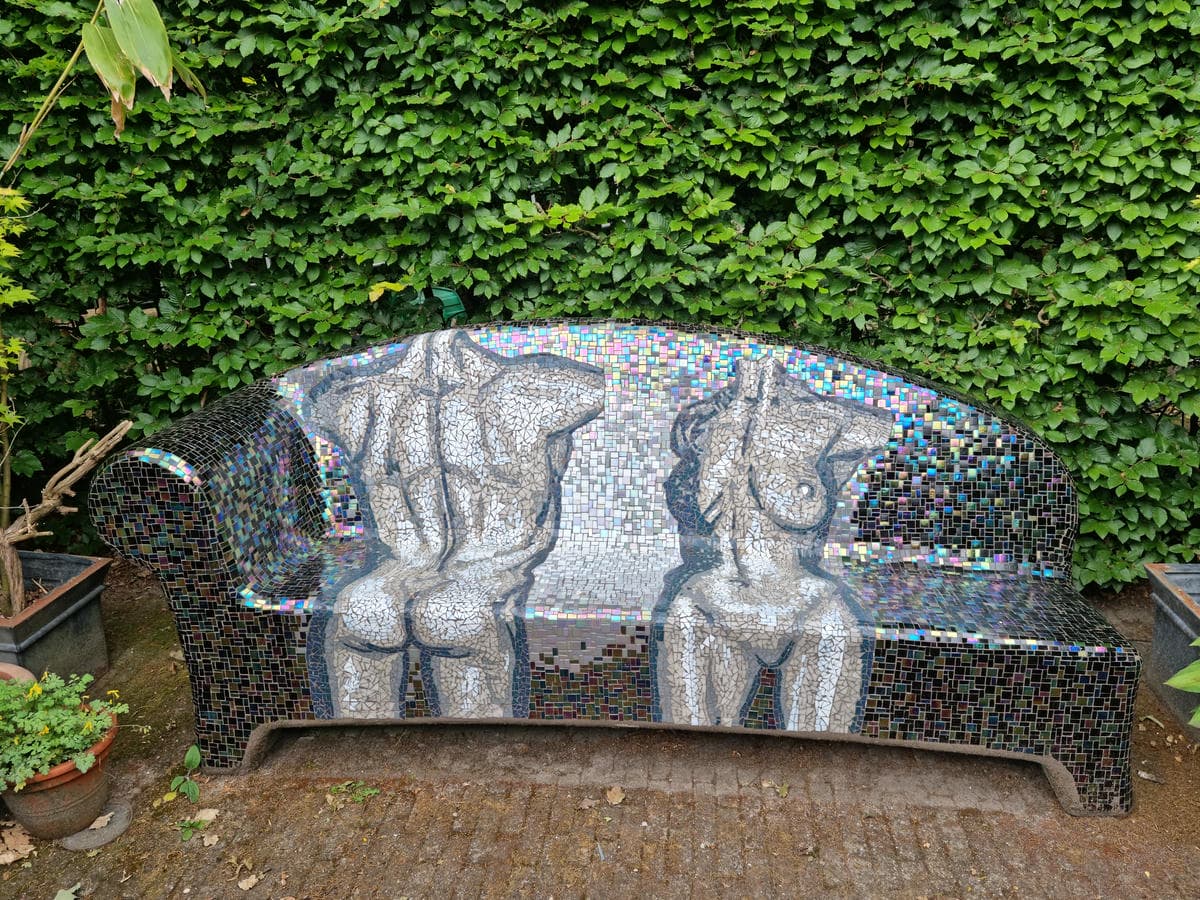 Garden Sofa inspired by a sculpture by sculptor David Begbie depicting two human figures in front of a green hedge.