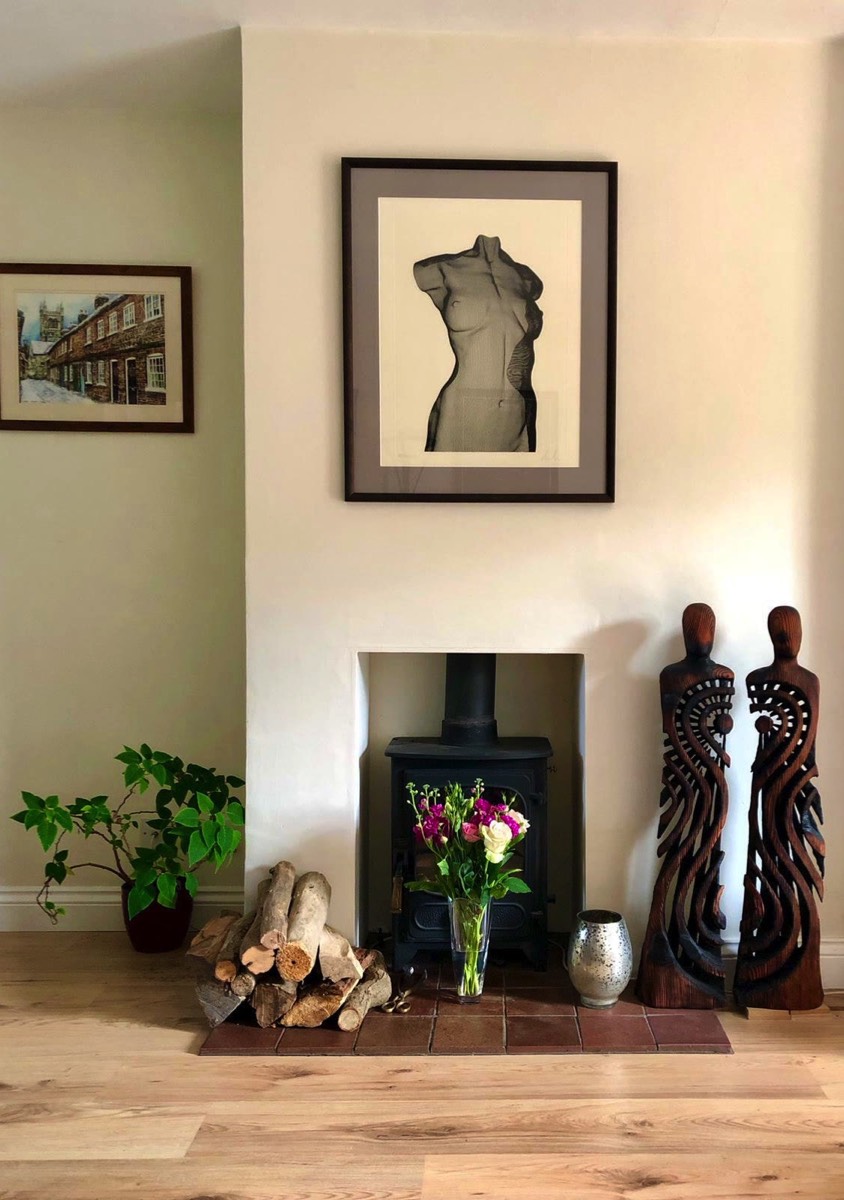 A fireplace is surrounded by contemporary art.